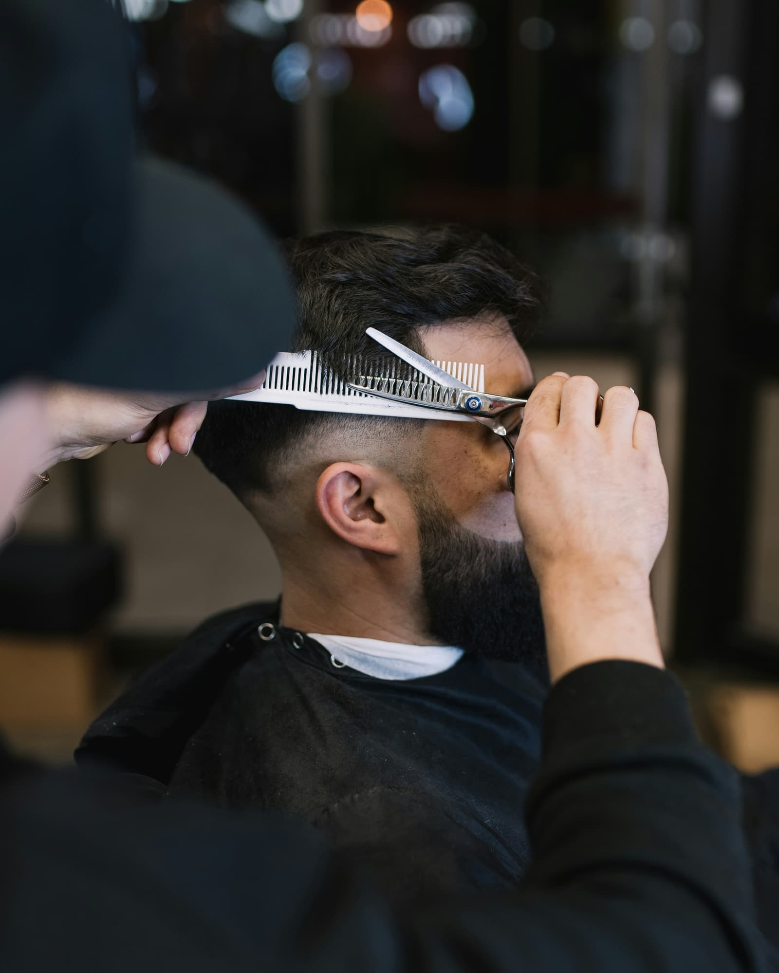 Barber giving a skin fade in a modern barbershop