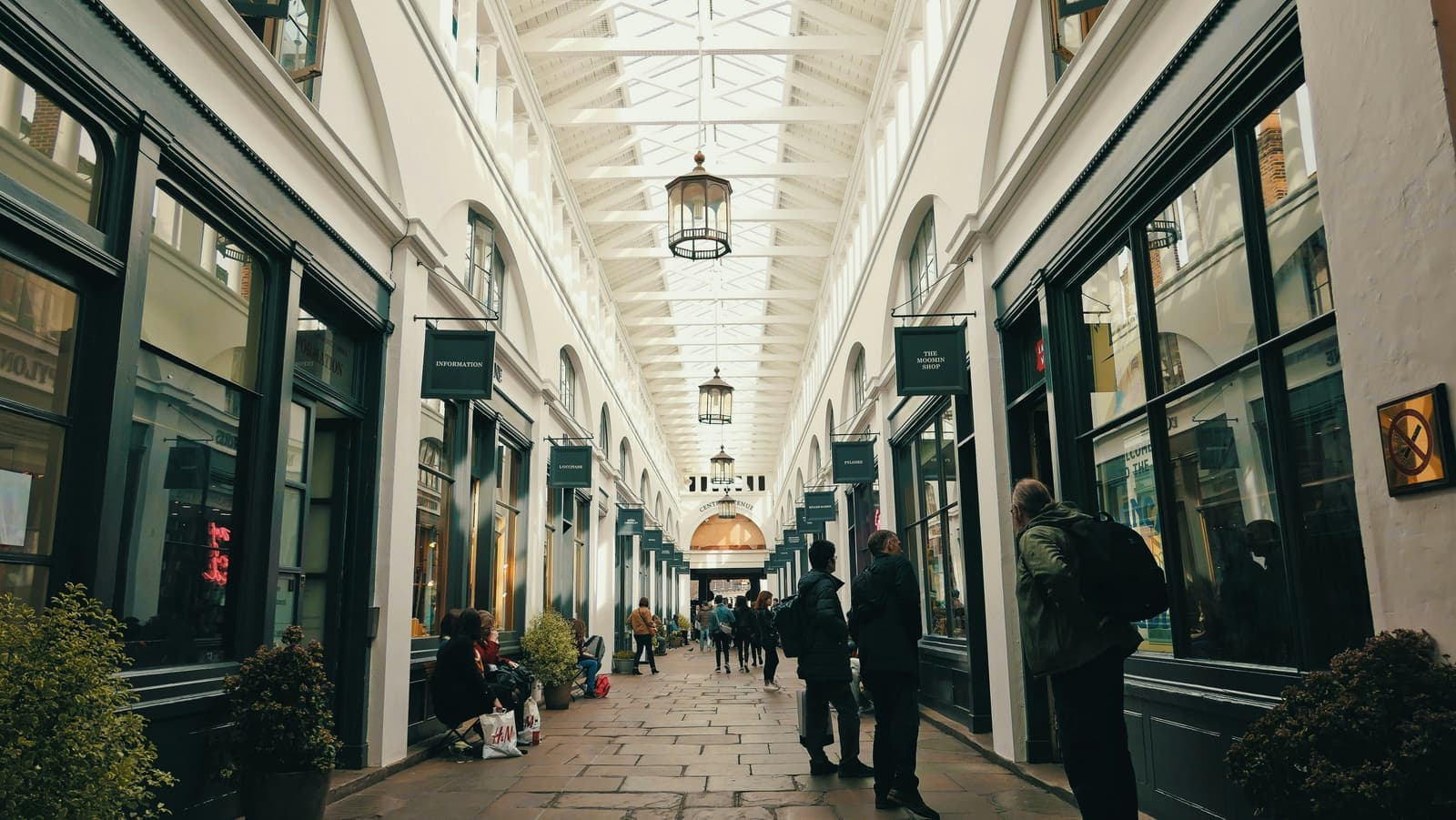 A busy indoor shopping arcade with independent shopfronts